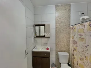Foto de um banheiro com revestimento cerâmico e armário de madeira.