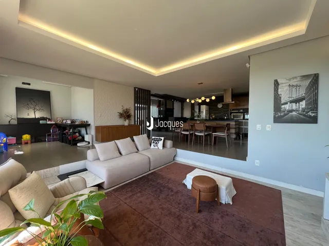 Sala de estar moderna com sofá e piso de madeira.