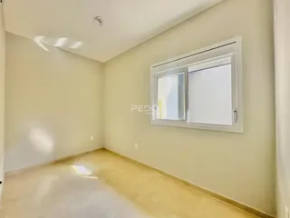 Ambiente interno de uma sala com paredes claras e piso de cerâmica.