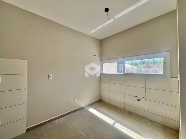 Ambiente interno de uma sala com paredes brancas e piso claro.