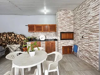 Foto de uma sala de jantar com mesa branca e cadeiras em um ambiente com parede de pedra.