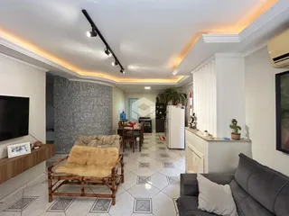 Sala de estar com piso de cerâmica e móveis de vime.
