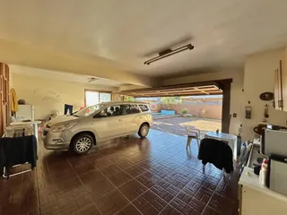 Sala de estar com um veículo estacionado e acesso a um pátio externo.