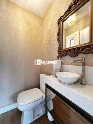 Banheiro com vaso sanitário e pia de apoio.