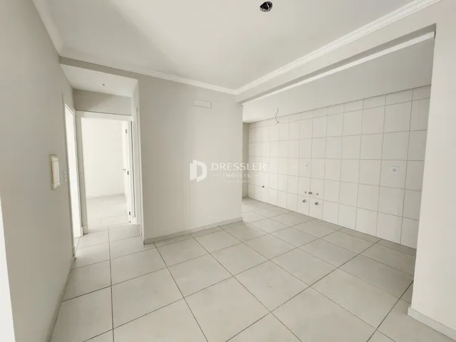 Hall de entrada com piso de cerâmica e paredes brancas.