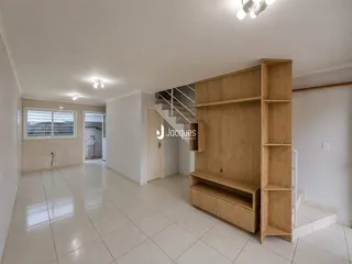 Hall de entrada com piso de cerâmica e estante de madeira.