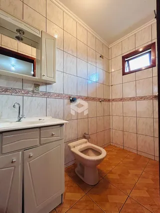 Foto de um banheiro com piso de cerâmica e paredes de azulejo.