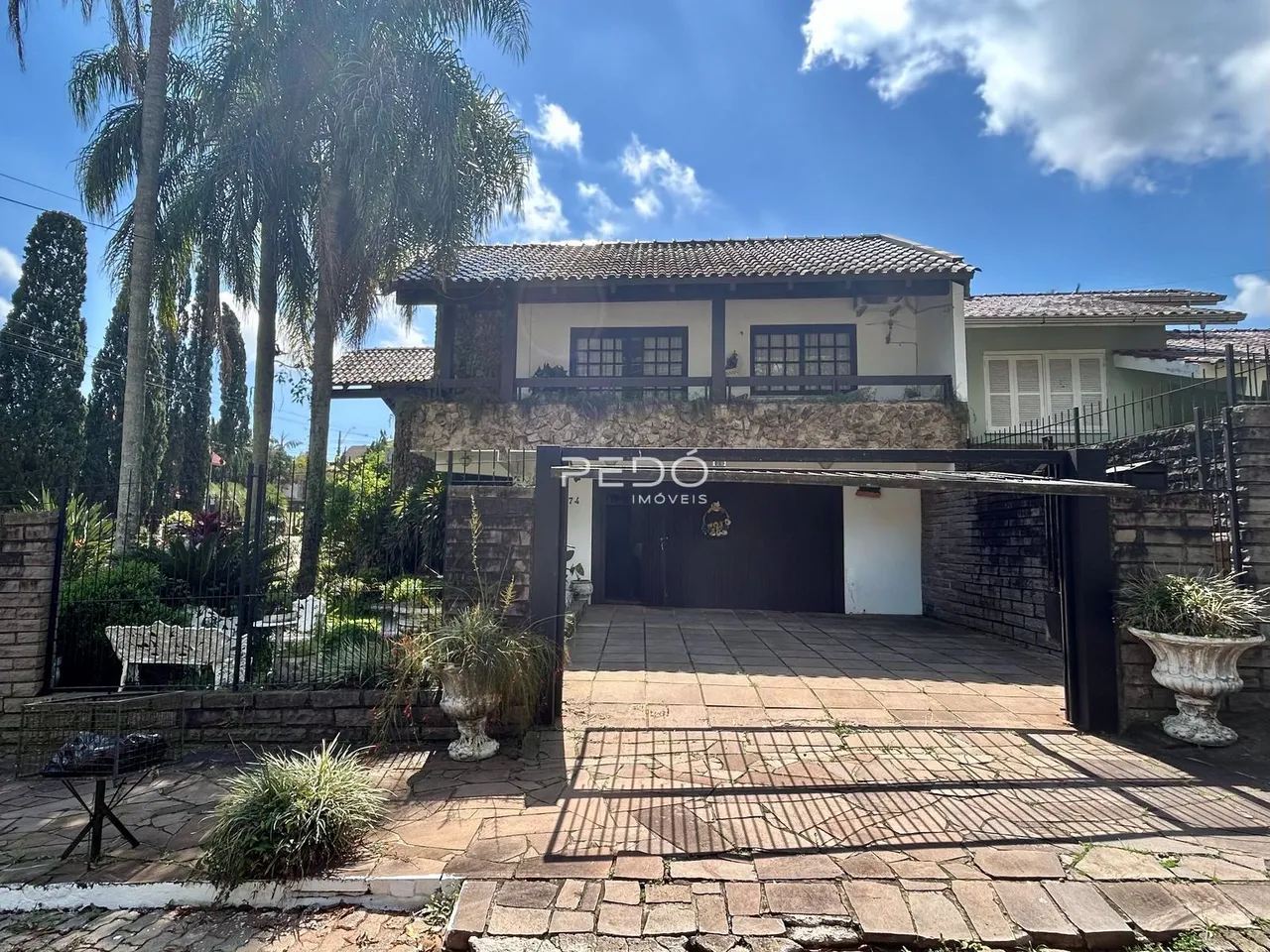 Fachada de uma residência em Lajeado, Brasil, com portão e área pavimentada.