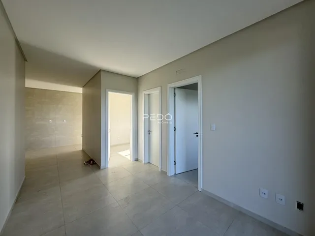 Hall de entrada com piso claro e paredes brancas.