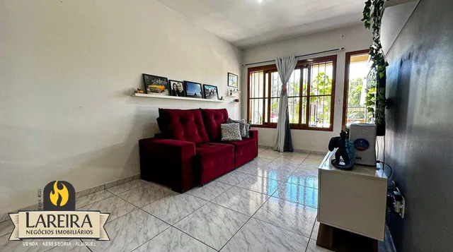 Sala de estar com sofá vermelho e piso de cerâmica.