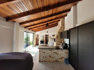 Interior de uma sala com teto de madeira e parede de tijolos aparentes.