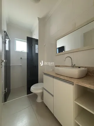 Banheiro moderno com bancada e espelho.