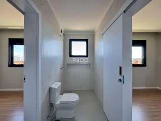 Vista de um corredor com banheiro em um imóvel no Brasil.