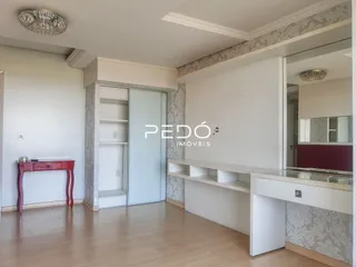 Interior de um ambiente com paredes brancas e piso de madeira clara.