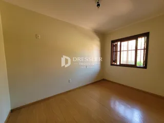 Foto de um ambiente interno com piso de madeira e grande janela.