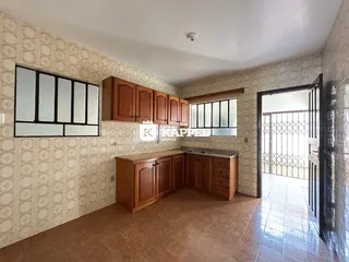 Foto interna de uma cozinha com armários de madeira e piso de cerâmica.