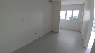 Interior de um ambiente com paredes brancas e piso claro.