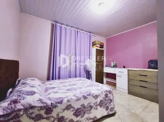 Quarto com cama e cortinas roxas em uma sala de estar.