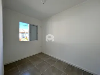 Quarto vazio com piso de cerâmica e janela de vista para o exterior.