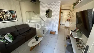 Sala de estar com sofá e escadaria em um apartamento.