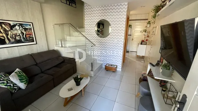 Sala de estar com sofá e escadaria em um apartamento.