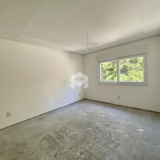 Foto de um cômodo vazio com paredes brancas e piso de concreto.