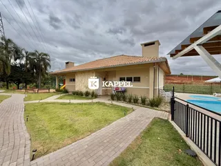 Foto da fachada de uma casa em Lajeado, Brasil, mostrando o jardim e a piscina.