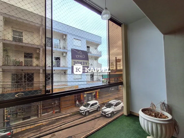Vista da rua com carros estacionados e edifícios no bairro de Lajeado.