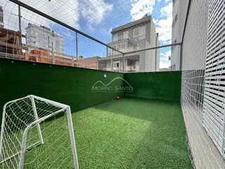 Quintal com grama artificial e estrutura de gol em área externa.