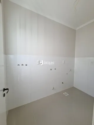 Interior de um cômodo com paredes brancas e piso claro.