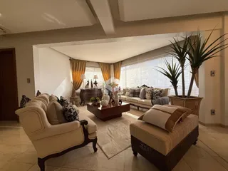 Sala de estar com sofá e decoração em ambiente claro.