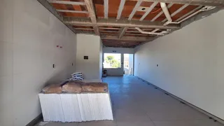 Corredor com teto de madeira exposta e paredes brancas em uma residência.