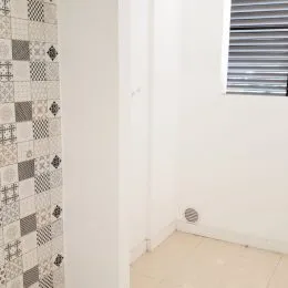 Parede interna com revestimento de azulejos na área do imóvel.