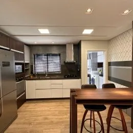 Ambiente interno com mesa de madeira e armários na sala.