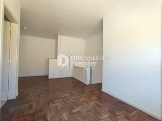 Interior de uma sala com piso de madeira clara.
