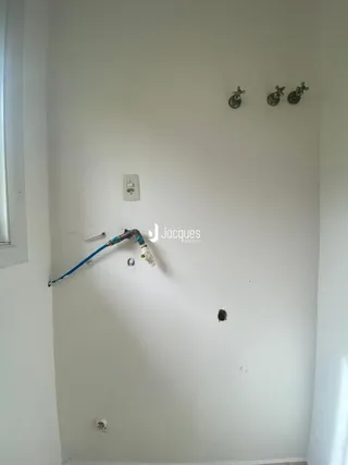 Parede interna com tubulações e uma janela em uma residência.
