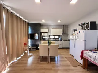Ambiente interno de sala de estar com piso de madeira e lareira.