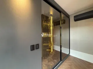 Vista de um ambiente interno com portas de vidro e piso de madeira.