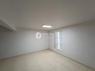 Ambiente interno de uma sala com piso de cerâmica e paredes brancas.