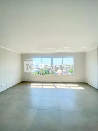 Sala ampla com grande janela voltada para o exterior.