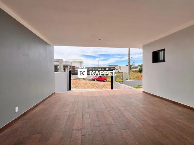 Vista de uma área externa com piso de cerâmica e acesso ao quintal.