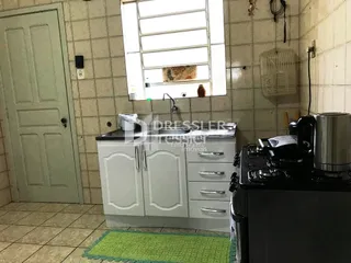 A cozinha apresenta armários brancos e piso de cerâmica.