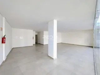 Hall de entrada com paredes brancas e piso claro.