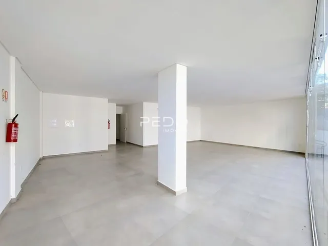 Hall de entrada com paredes brancas e piso claro.