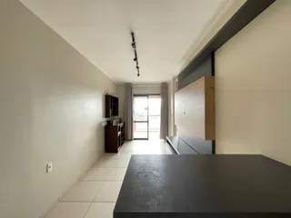Corredor interno de uma residência com piso de cerâmica clara.