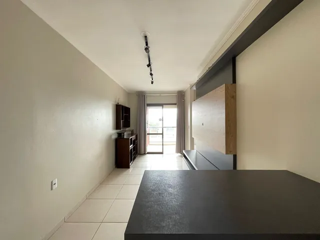 Corredor interno de uma residência com piso de cerâmica clara.