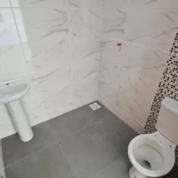 Foto de um banheiro com revestimento de azulejos brancos.