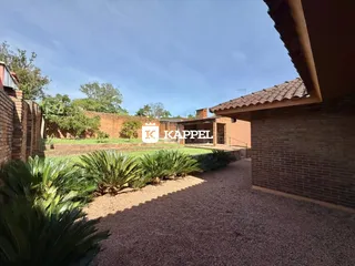 Vista externa mostrando a fachada de um imóvel com paisagismo tropical.
