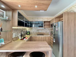 Imagem de uma cozinha moderna com armários de madeira e revestimento de azulejos.