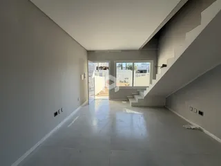 Hall de entrada com piso claro e paredes brancas em um imóvel.